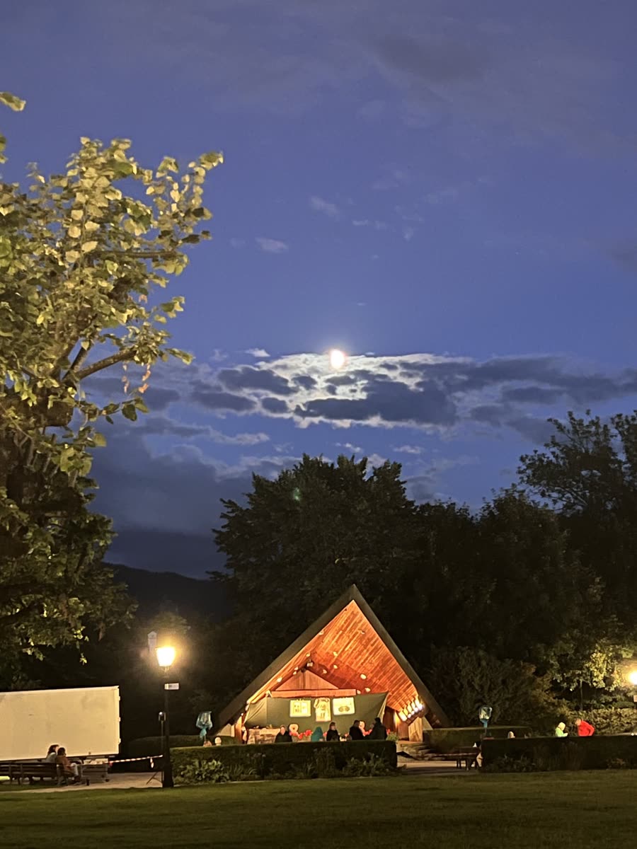 Die Freilichtbühne im Kurgarten Tegernsee am Abend, beleuchtet unter dem aufgehenden Mond